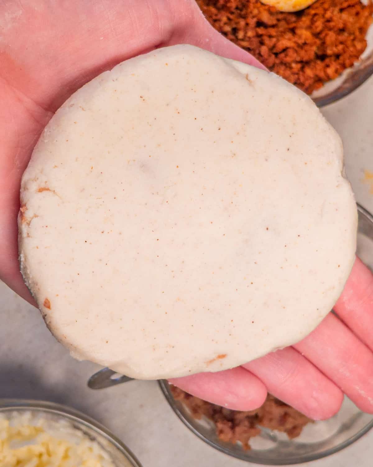 Raw pupusa round ready to be cooked.