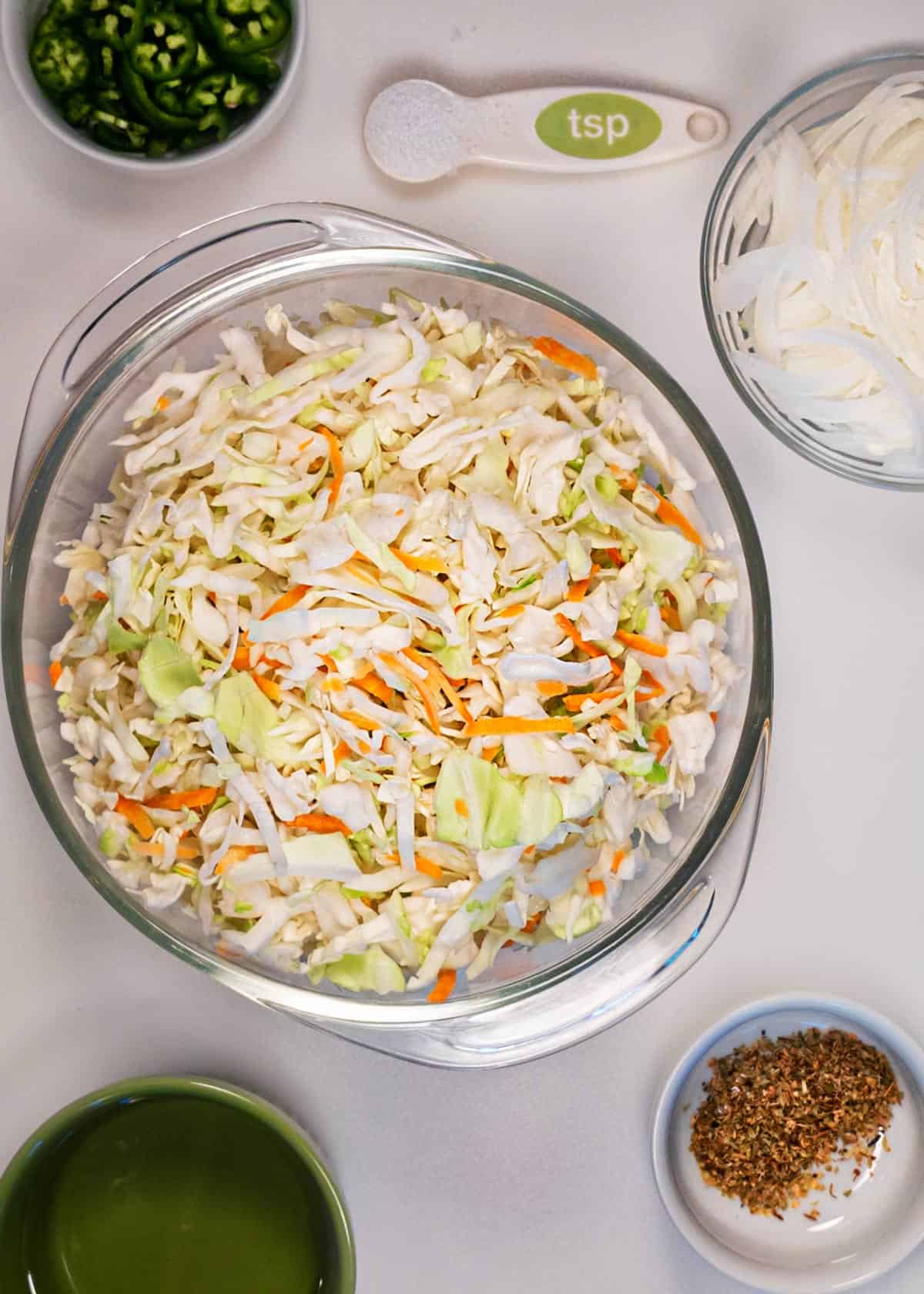 Cabbage, carrots, onions, and jalapenos on a board to make a slaw recipe for curtido.