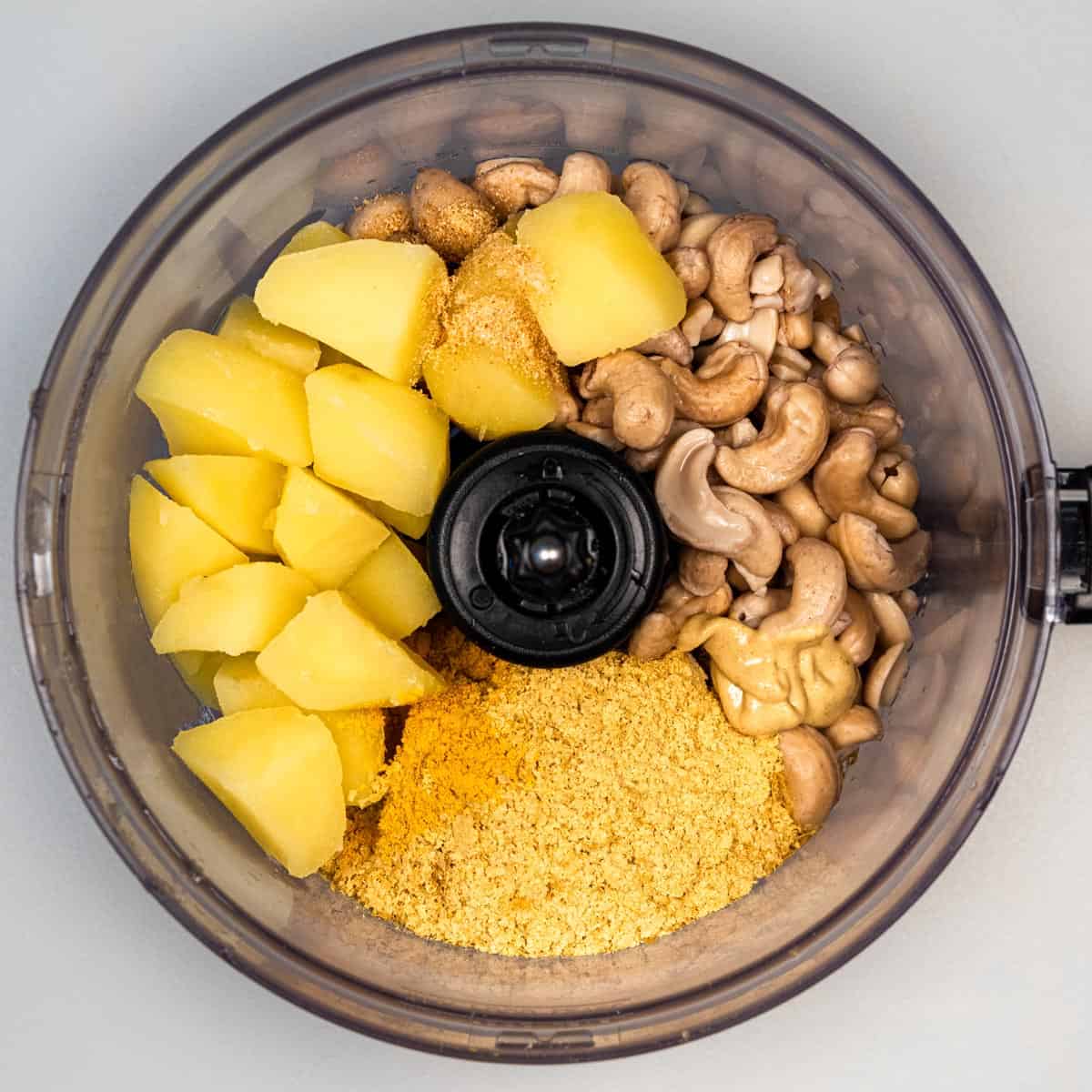 Cashews, potatoes, nutritional yeast, and garlic in a food processor.