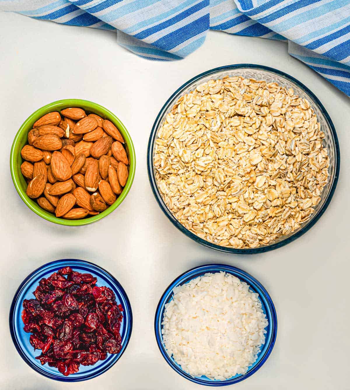 A bowl of oats, coconut, cranberries, and almonds.