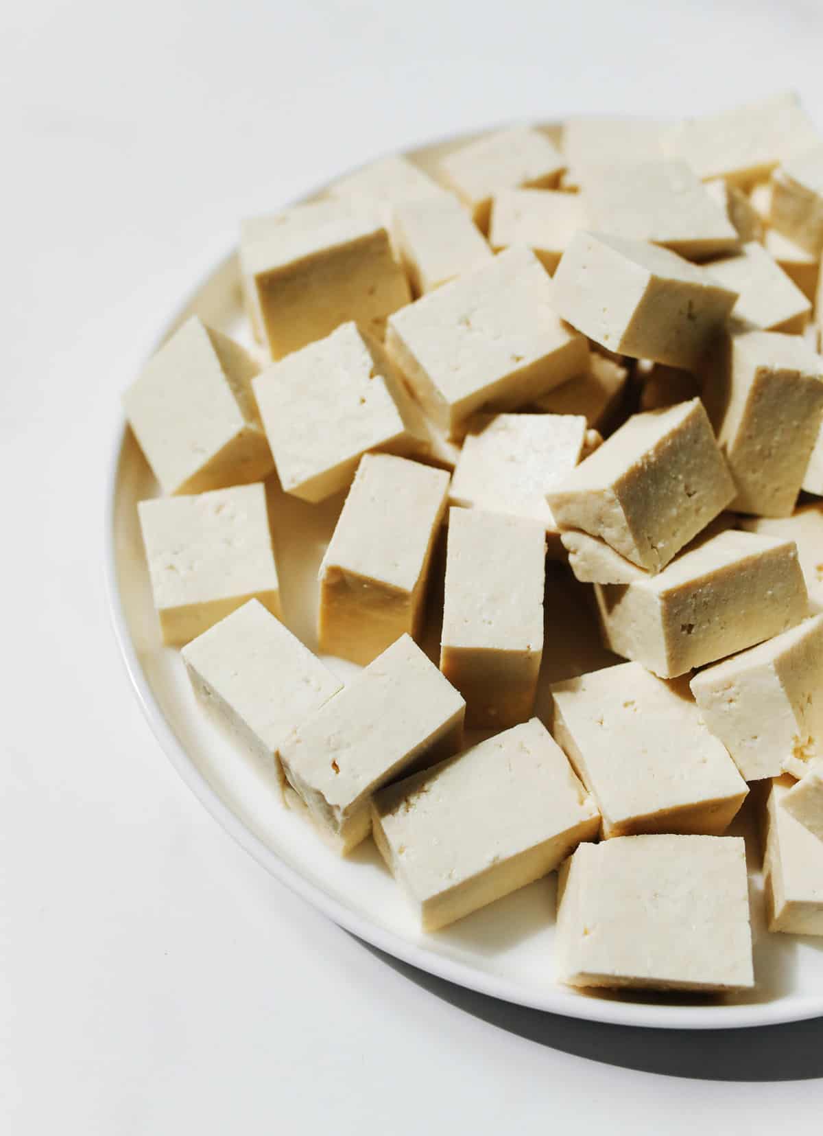 Plate of raw firm tofu cut into cubes