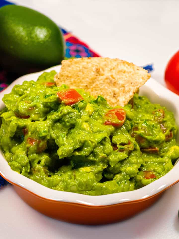 Guacamole in a dish with a toritall chip in it.