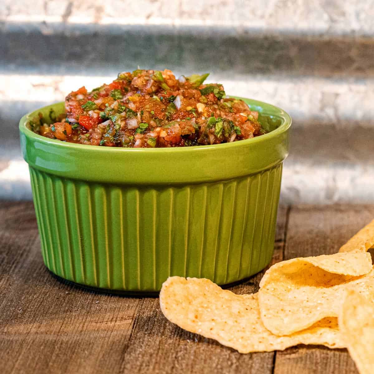 Restaurant style salsa in a green dish.