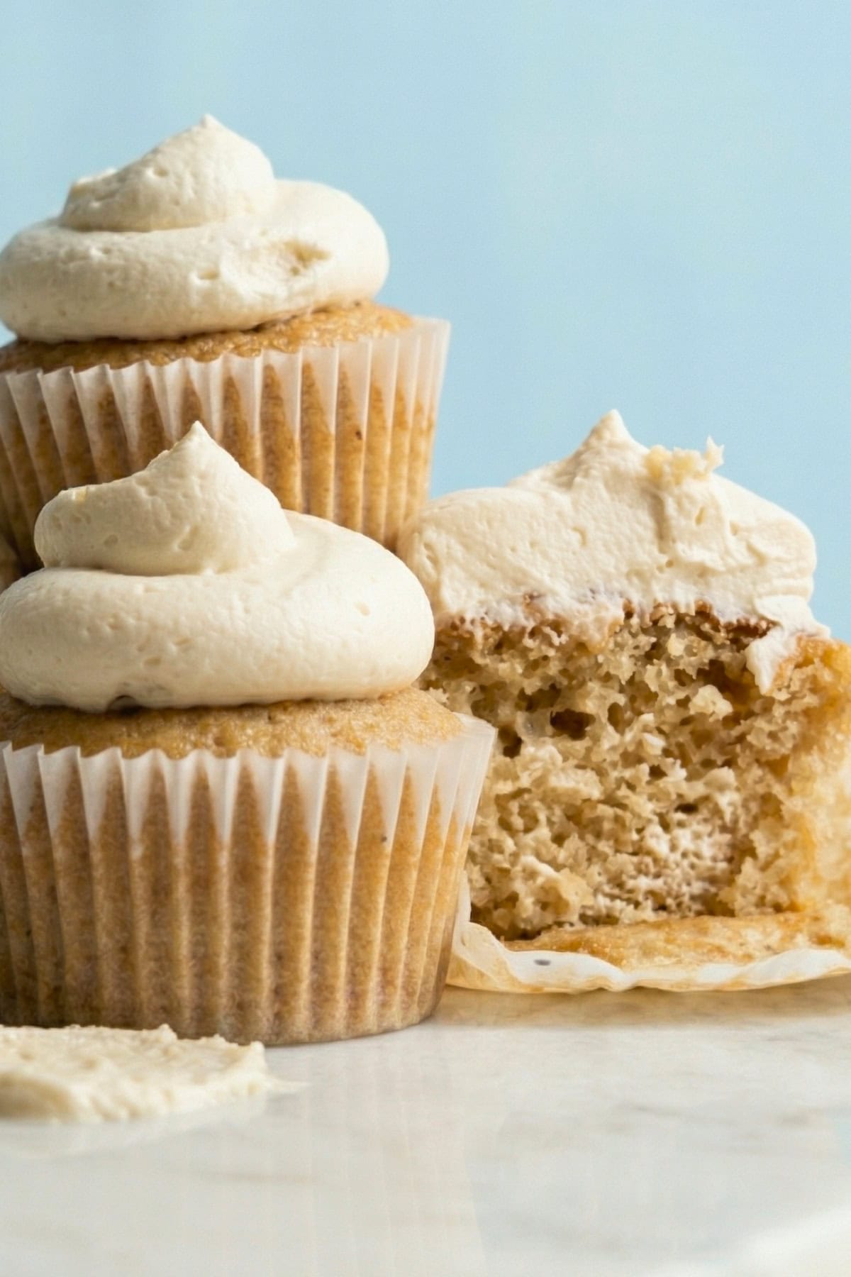 Vegan vanilla cupcakes topped with a swirl of white vanilla buttercream frosting.