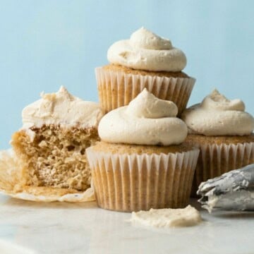 Vegan vanilla cupcakes topped with a swirl of white vanilla buttercream frosting.