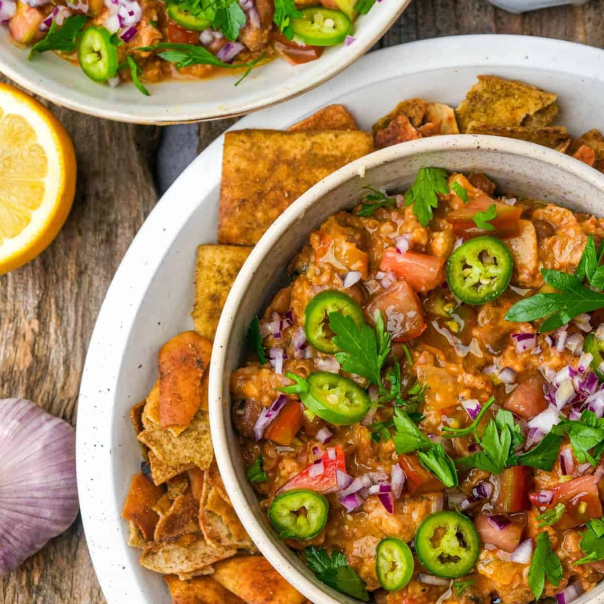 a dish of ful medames with pita chips.