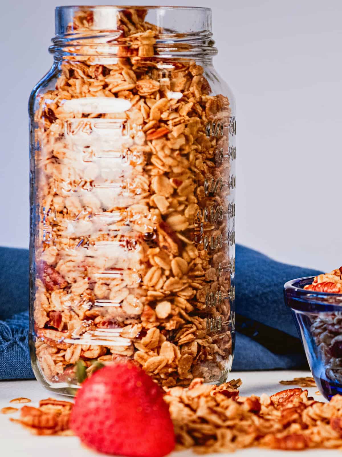 Homemade maple pecan granola in a glass storage jar.