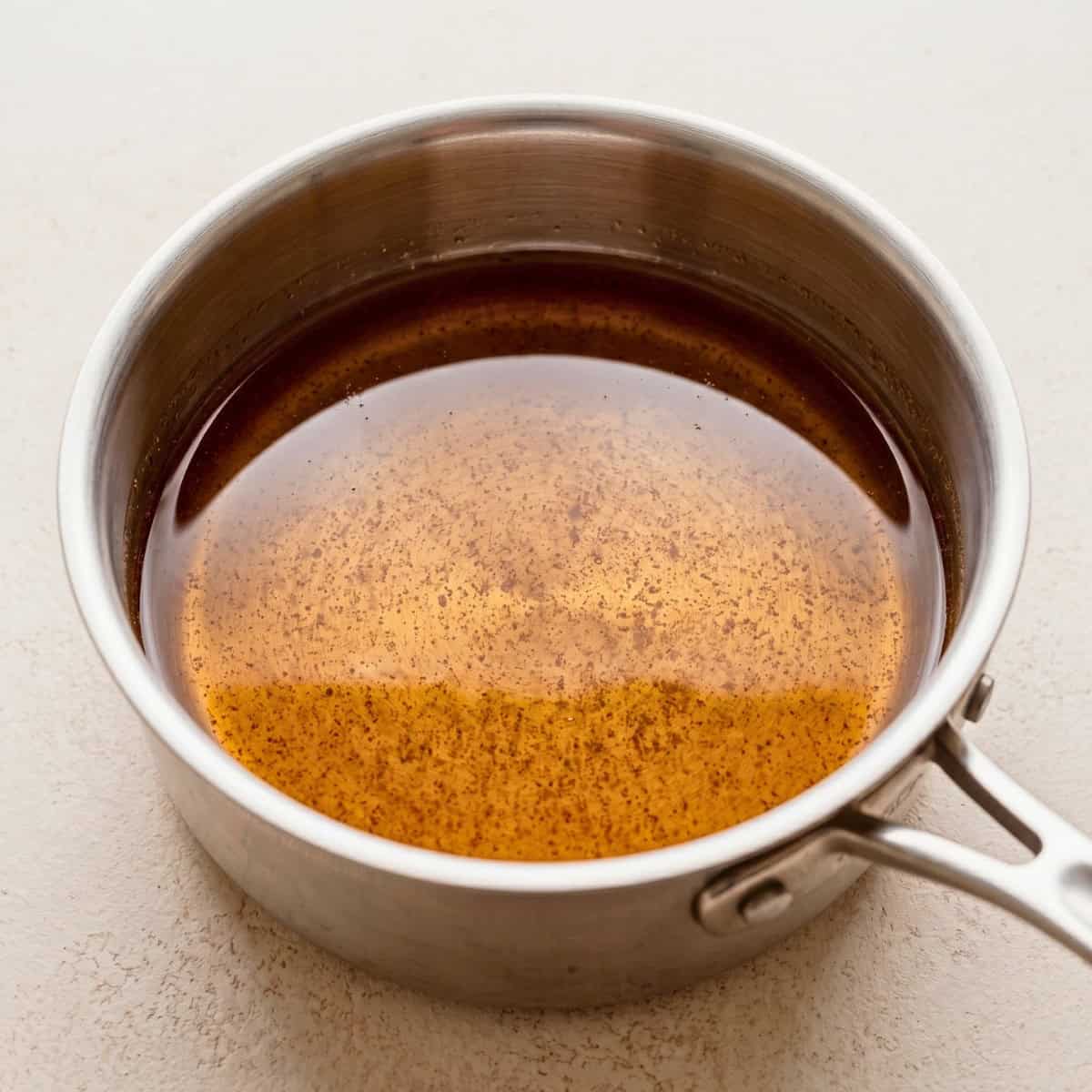 Warm maple syrup and melted coconut oil in a small saucepan.