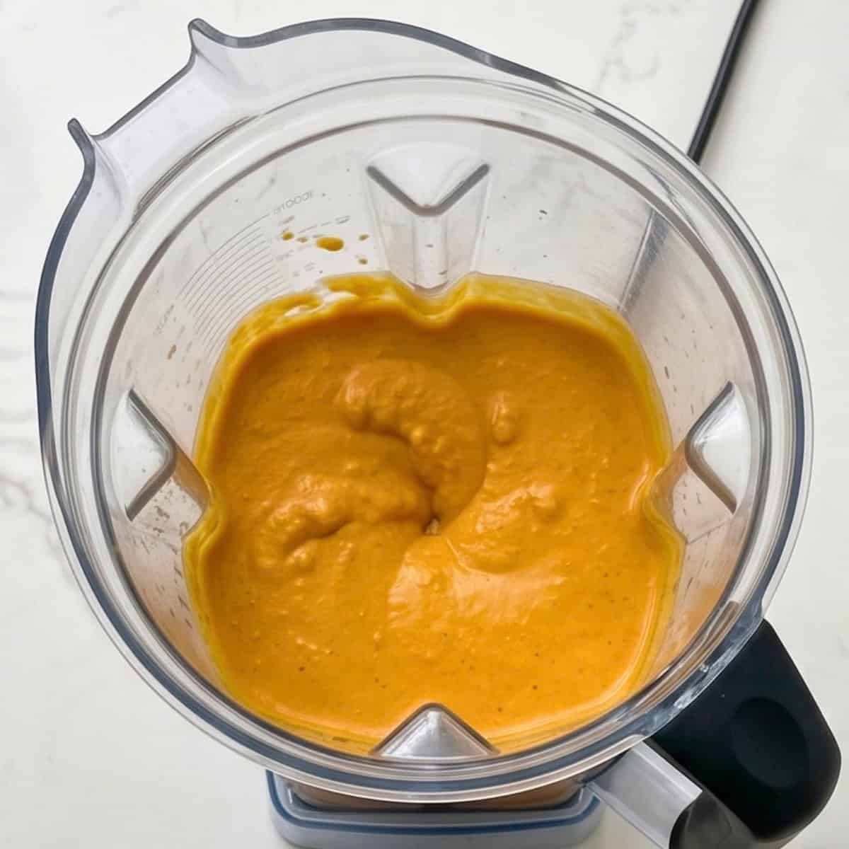 Smooth cashew pumpkin cheesecake filling blended until creamy in a blender.